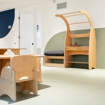 A Reggio-inspired playroom featuring Natural Pod's sustainable wood children's furniture, including an Imagine Play Stand, table, and chairs