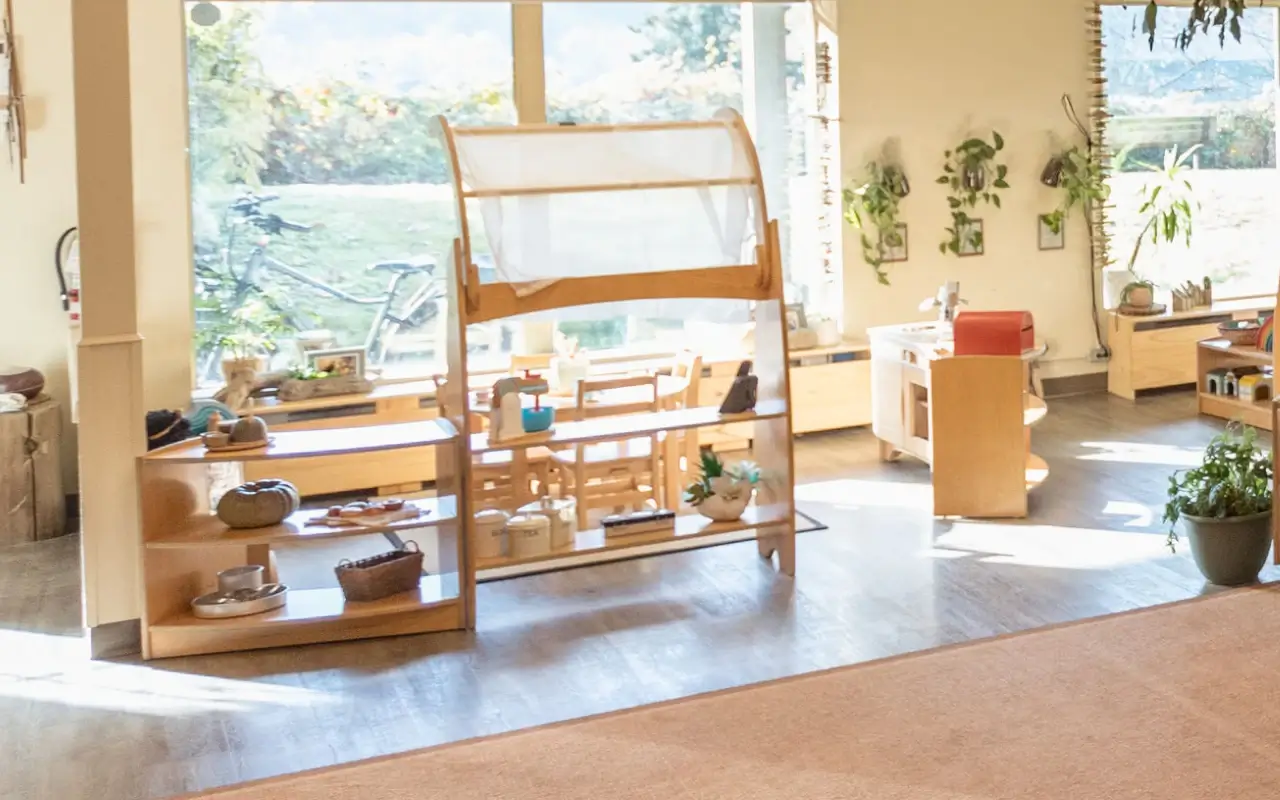 An open classroom with Natural Pod Evergreen Shelving and Imagine Play Stands, filled with plants and natural light.
