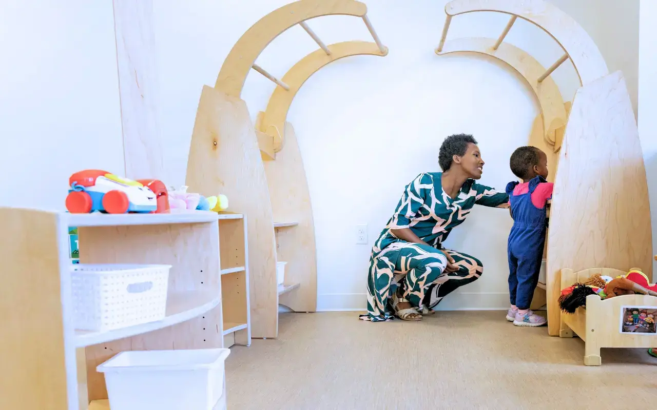An educator and child interact near Imagine Play Stands.