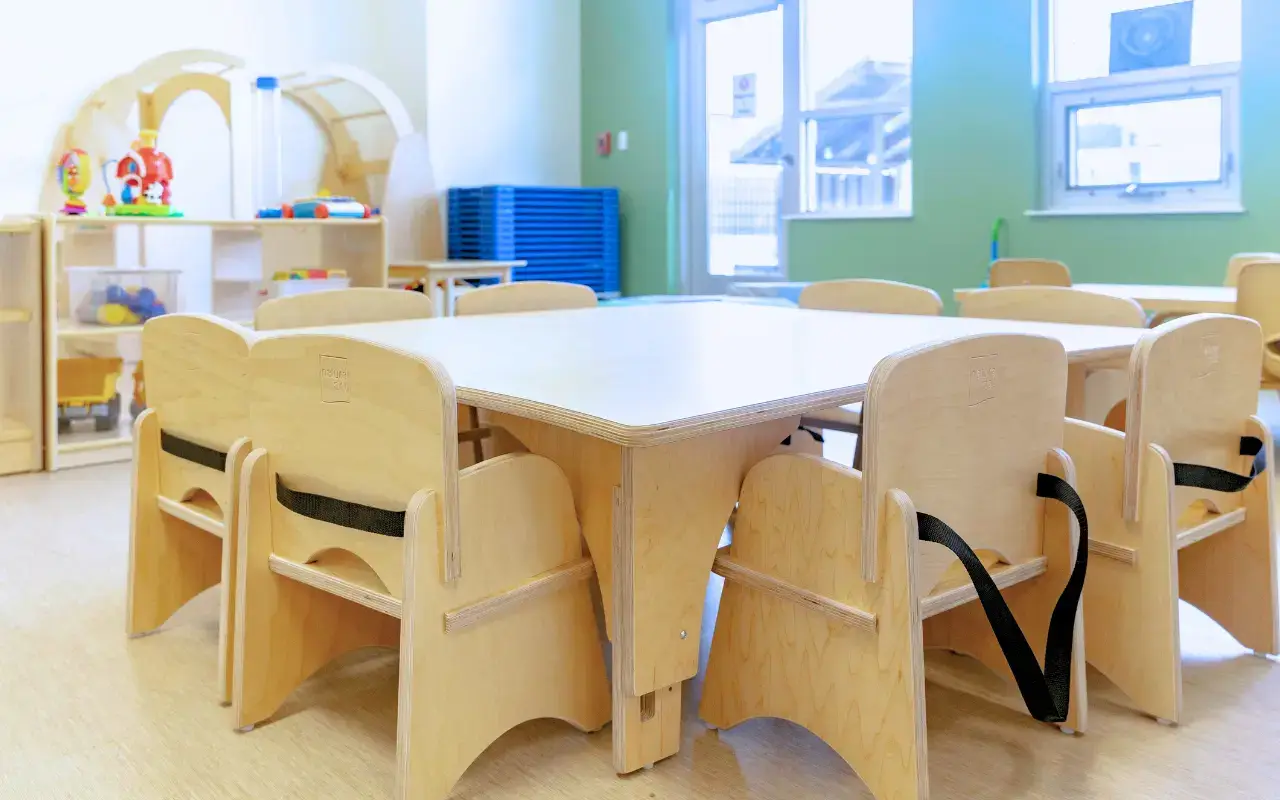 A Natural Pod Reach Table with several Steady Chairs sit ready for a new day of learning.