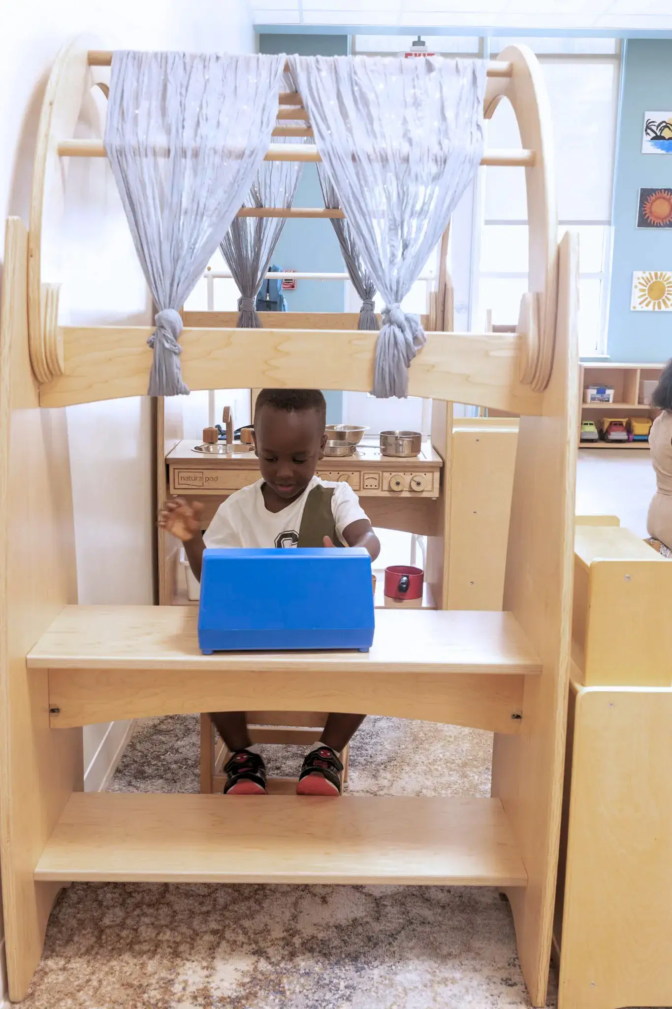 A child plays at a Natural Pod Imagine Play Stand.