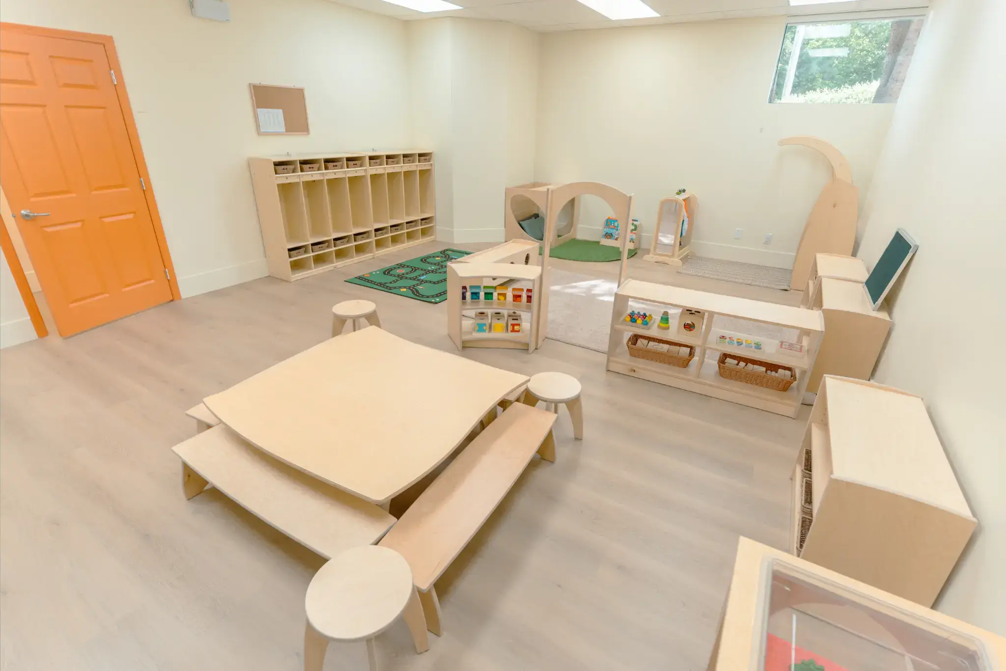 A bright, open playschool with Natural Pod furniture, including Reach Tables and Evergreen Shelving, for Tiny Scholars.