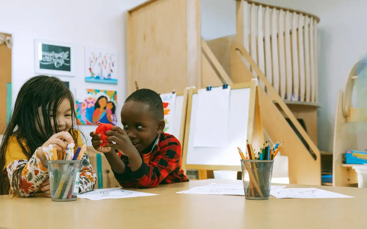 Two students work on an art project at a Natural Pod Reach Table, with a Wonder Loft in the background of the classroom. Two students work on an art project at a Natural Pod Reach Table, with a Wonder Loft in the background of the classroom.