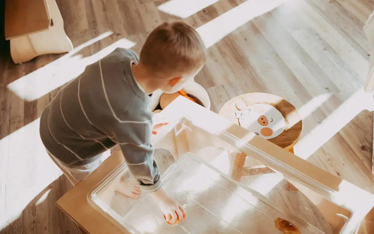 A child plays at a Natural Pod Reach Nature Table, a piece of sustainable preschool furniture.