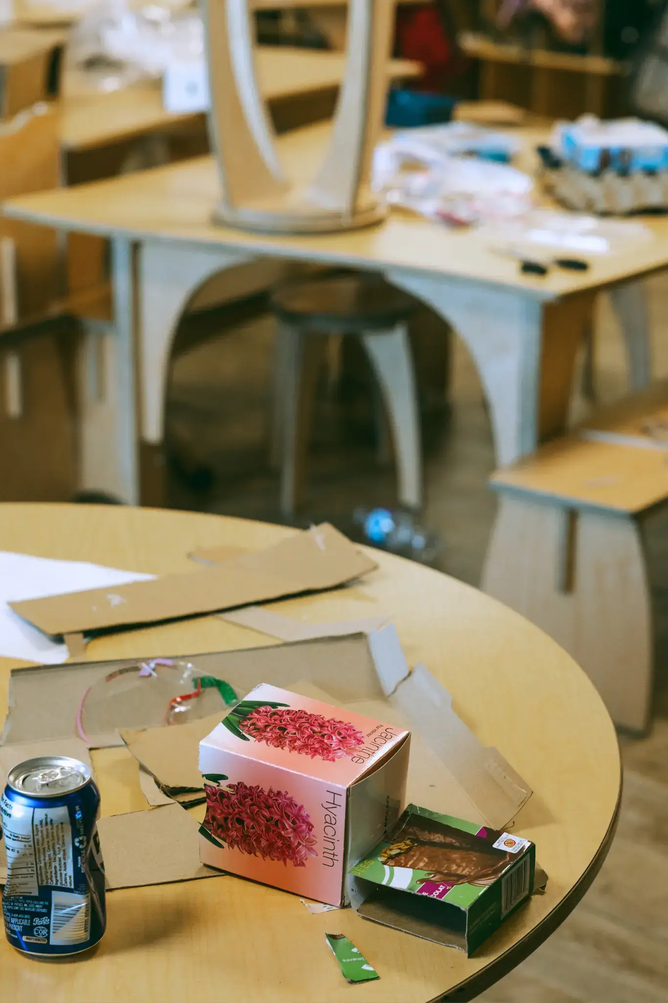 A Natural Pod Reach Table at Thrive Elementary covered in cardboard and supplies for a building project. A Natural Pod Reach Table at Thrive Elementary covered in cardboard and supplies for a building project.