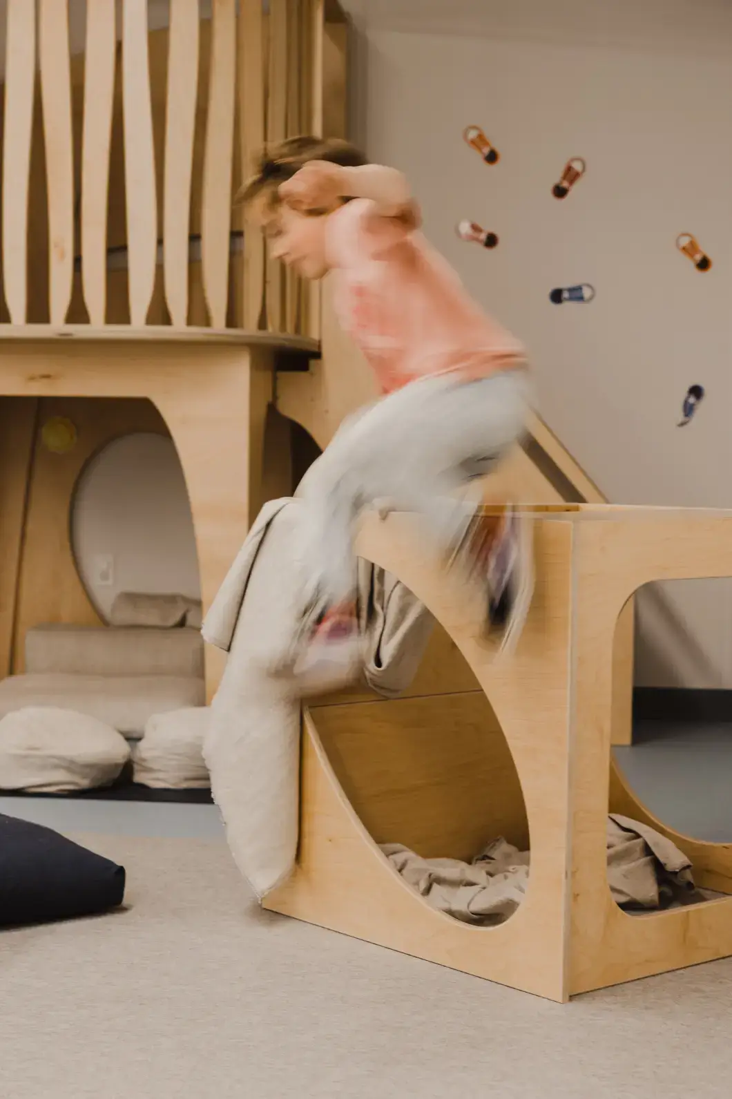 A child jumps from an Imagine Play Cube inside a learning space, engaging in risky play.<br />
