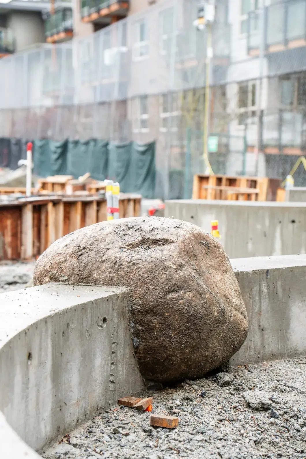 A large natural boulder embedded in a concrete wall at the West Vancouver Schools Early Childhood Education Centre.