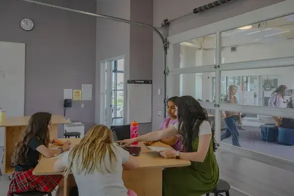 Students and an educator collaborating at a Junction Project Table in a St. Genevieve classroom.