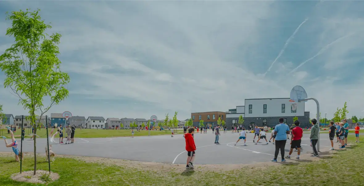 Students playing basketball and doing gymnastics outside at St. Genevieve Catholic School.