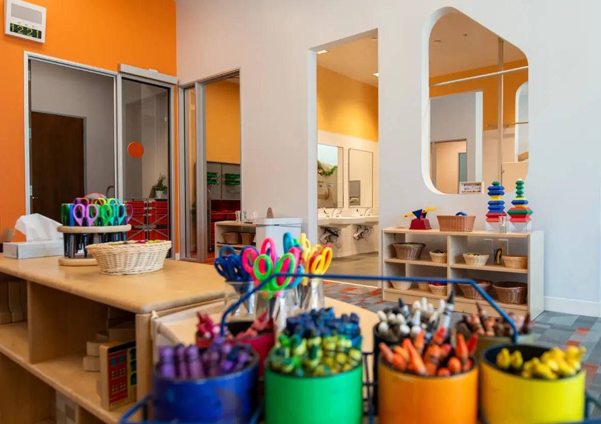 Close up of colorful art supplies organized on an Evergreen Shelving unit in an early learning environment.