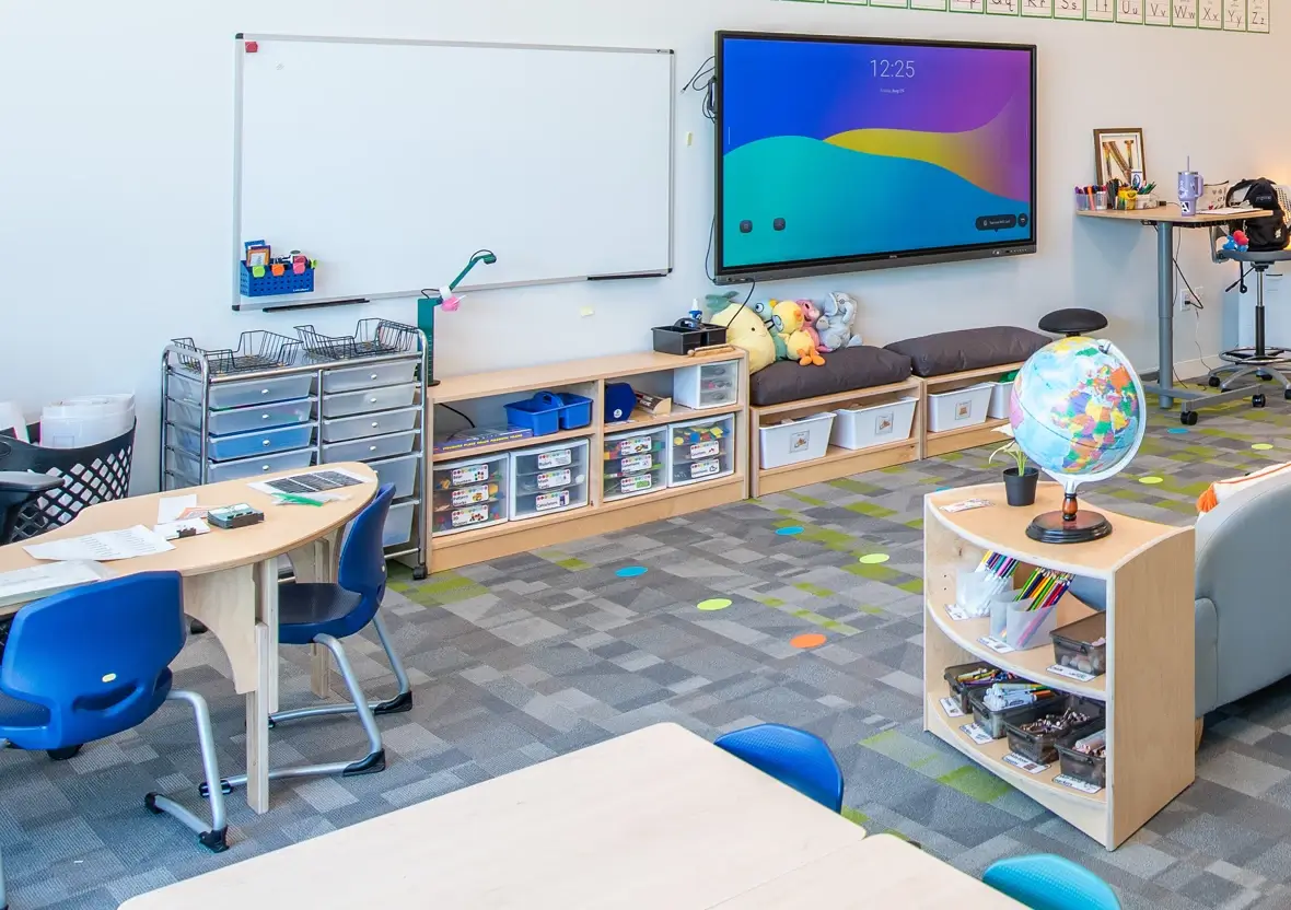 Early learning space featuring a digital display, whiteboard, and Evergreen Shelving.