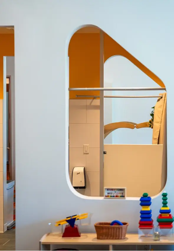 Natural light streaming through a geometric wall cutout at the Thompson Family Early Education Center.