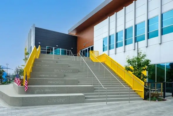 Modern school exterior of the Thompson Family Early Learning Center St. Mary’s School with wide concrete stairs featuring engraved values.