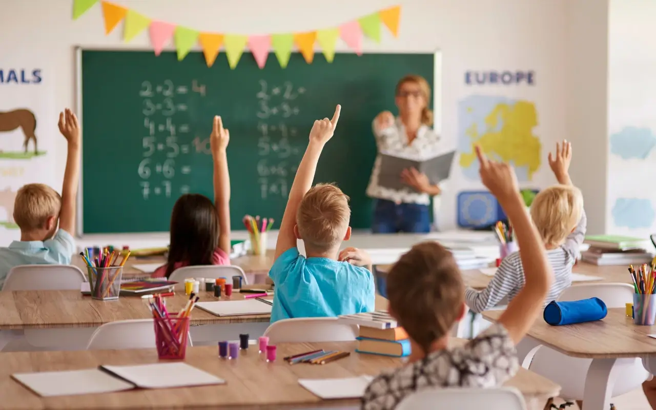 Students in Classroom with hands raised