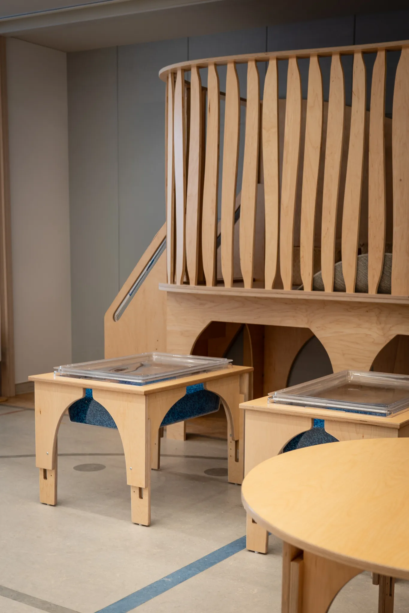 Natural Pod furniture including a Play Loft, two Reach Nature Tables, and a Reach Table in a Nishimachi International School classroom.