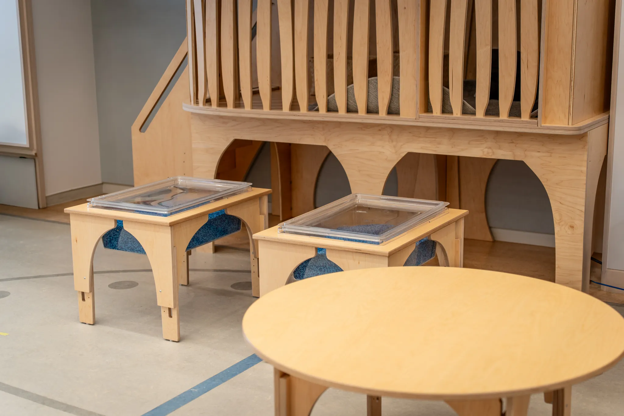 Natural Pod furniture including a Play Loft, two Reach Nature Tables, and a Reach Table in a Nishimachi International School play area.