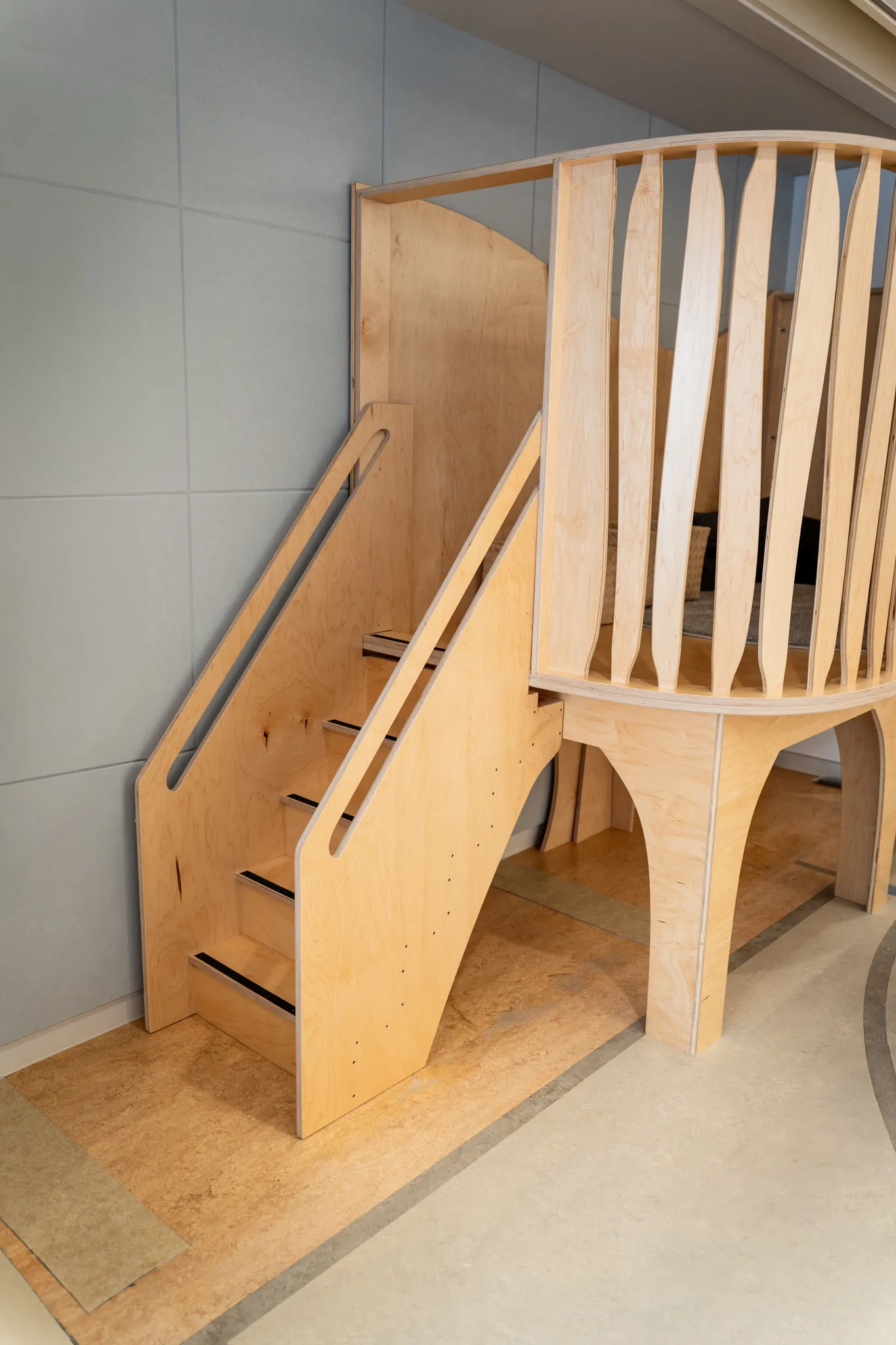 Close-up view of the wooden stairs and slatted railing on a Natural Pod Wonder Play Loft at Nishimachi International School.